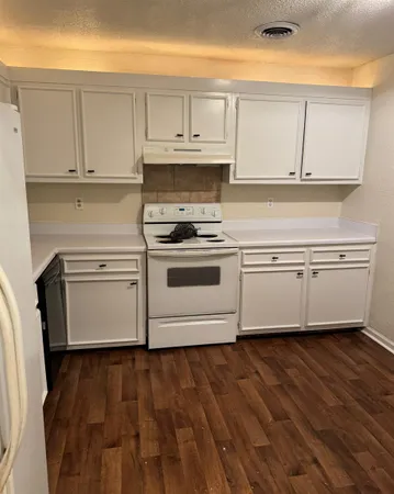 a white kitchen with granite countertop white cabinets and white appliances