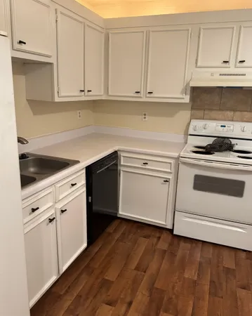 a kitchen with granite countertop white cabinets and white appliances