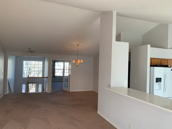 a view of an empty room with a kitchen