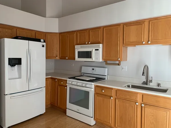 a white kitchen with stainless steel appliances granite countertop a refrigerator stove a sink dishwasher and microwave with cabinets