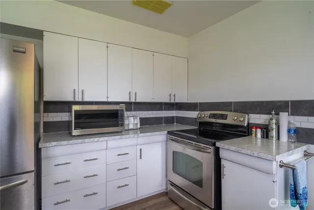a kitchen with white cabinets and stainless steel appliances