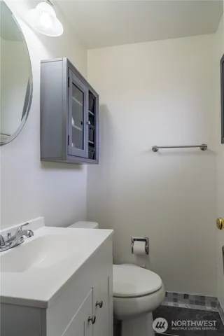a bathroom with a toilet a sink and mirror