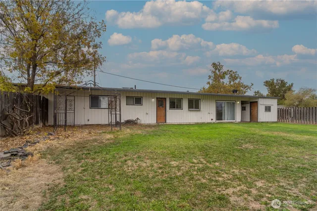 a view of a yard in front of a house with a large tree