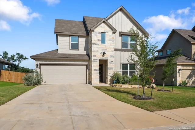 a front view of a house with a yard and trees