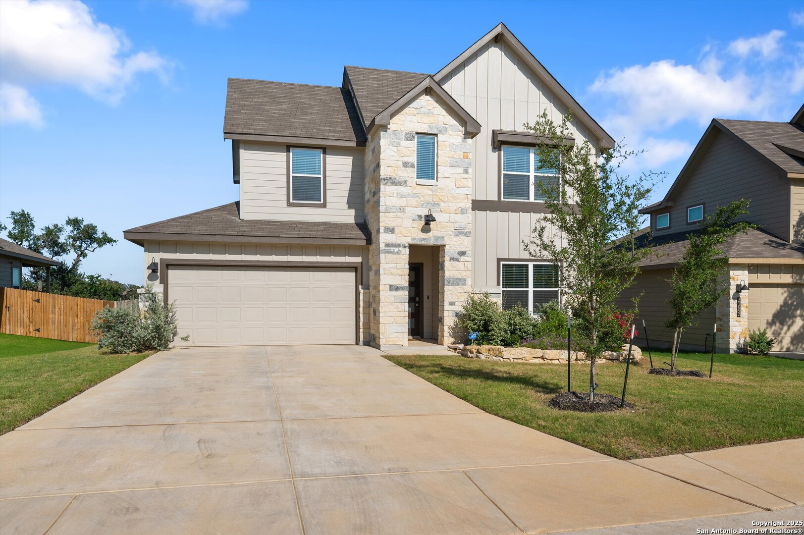 a front view of a house with a yard and trees