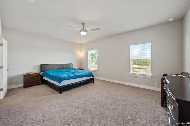 a living room with furniture a ceiling fan and a window