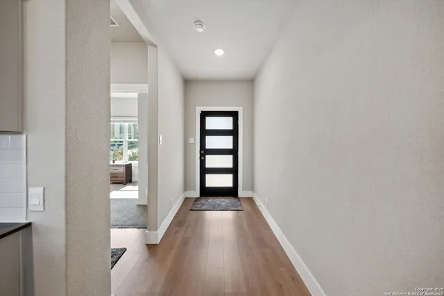 a view of a hallway with wooden floor and staircase