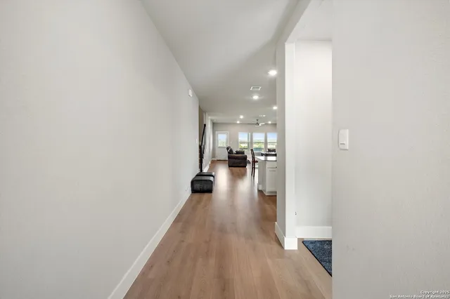 a view of a hallway with wooden floor