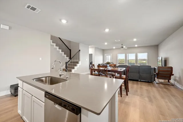 a kitchen with a sink a counter and chairs