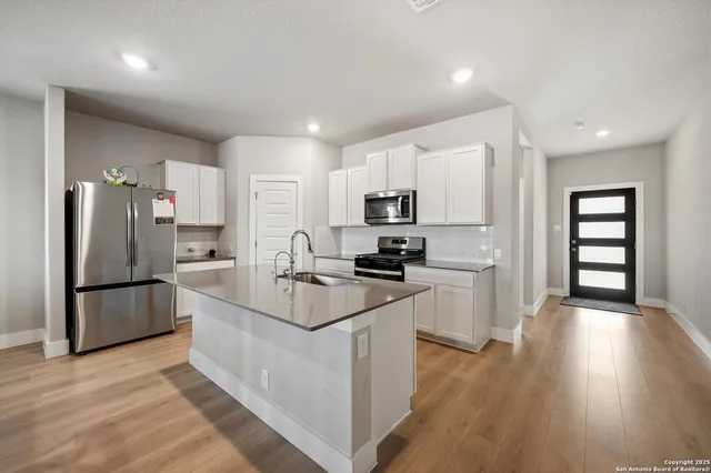 a kitchen with white cabinets and stainless steel appliances