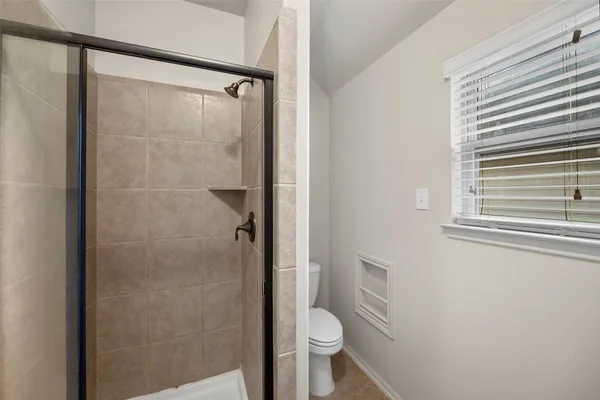 a bathroom with a toilet and a shower