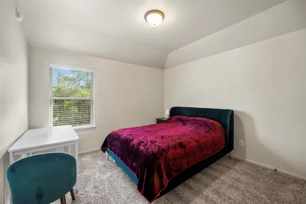 a bed sitting in a bedroom next to a window