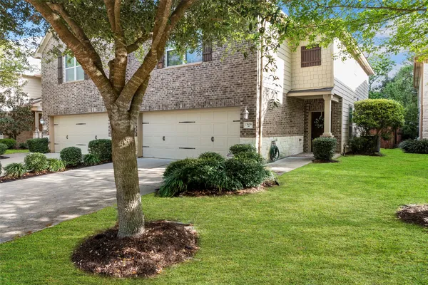 a front view of a house with a yard and trees