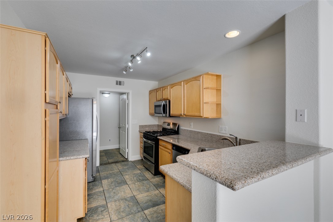 200 Luninborg Street Henderson, NV 89074 - Photo 36 of 40 A well-appointed kitchen offers ample counter space, rich cabinetry, and modern appliances for culinary pursuits.