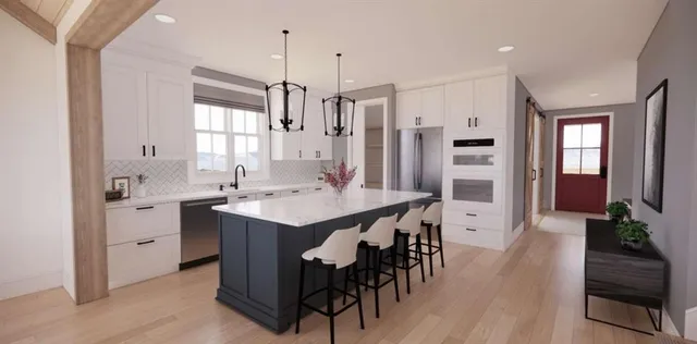 a large kitchen with kitchen island a large window in it