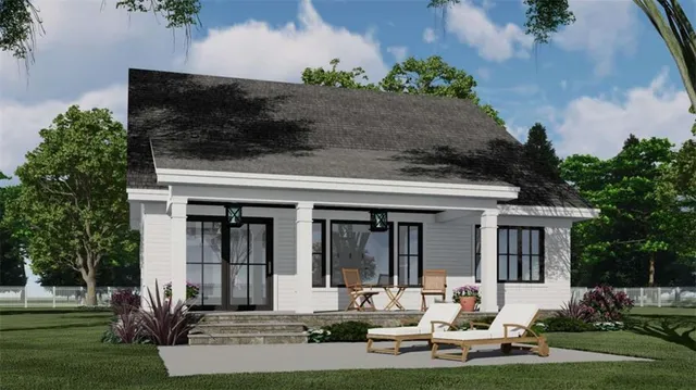 front view of house with a yard potted plants and a table