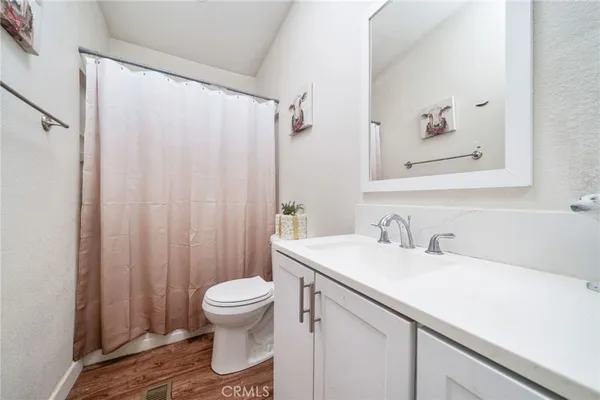a bathroom with a sink a toilet and shower curtain
