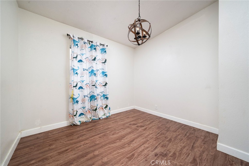 13221 Arena Road Pinon Hills, CA 92372 - Photo 13 of 19 a view of a hallway with wooden floor and a chandelier