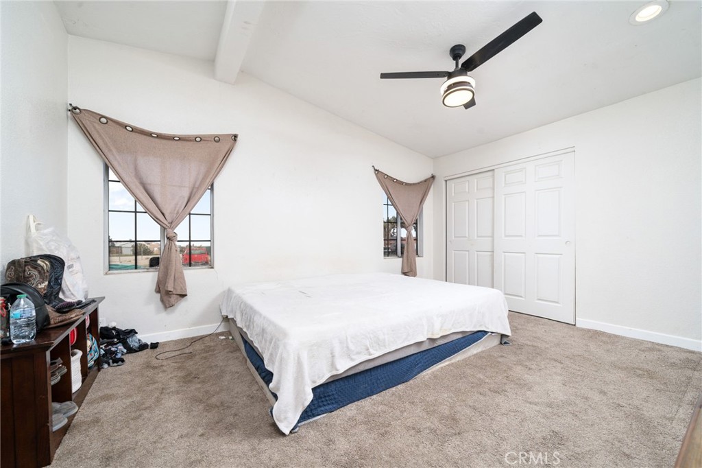 13221 Arena Road Pinon Hills, CA 92372 - Photo 14 of 19 a bedroom with a bed a window and gym equipment