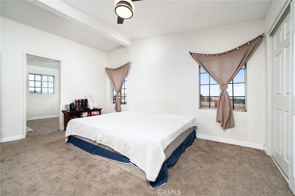13221 Arena Road Pinon Hills, CA 92372 - Photo 15 of 19 a spacious bedroom with a bed and window