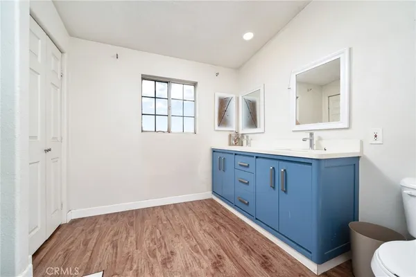 a bathroom with a sink a toilet a mirror and window