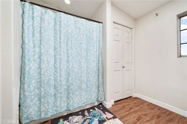 a view of a room with wooden floor and a window