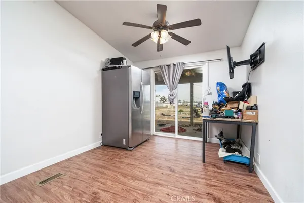 a view of a room with wooden floor and ceiling fan