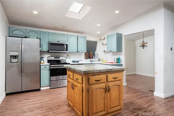 a kitchen with stainless steel appliances granite countertop a stove a refrigerator and a microwave
