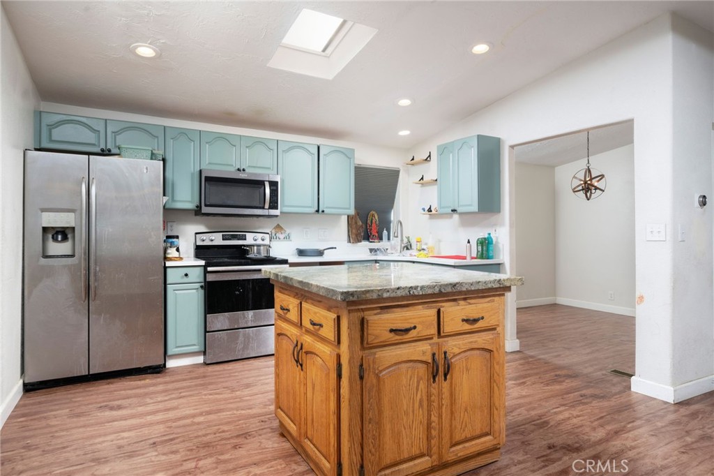 13221 Arena Road Pinon Hills, CA 92372 - Photo 7 of 19 a kitchen with stainless steel appliances granite countertop a stove a refrigerator and a microwave