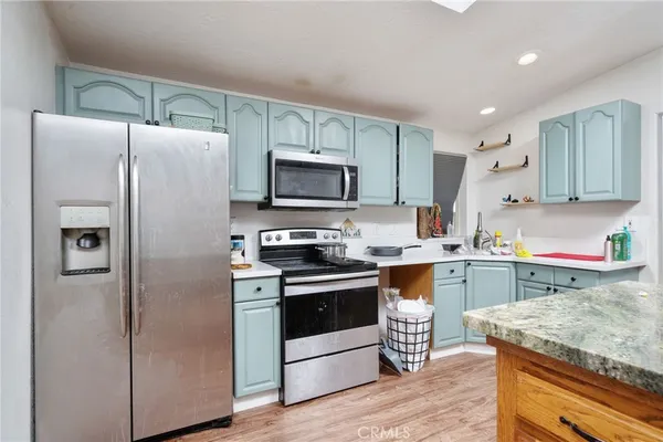 a kitchen with granite countertop a refrigerator stove and sink