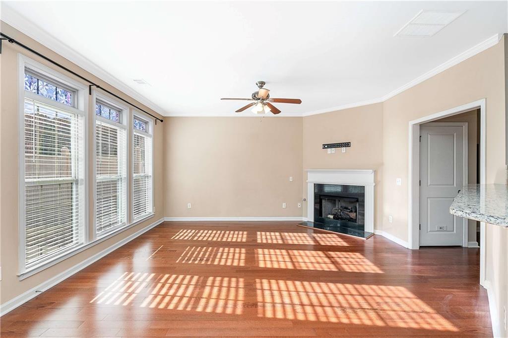 3546 Flycatcher Way Duluth, GA 30097 - Photo 11 of 30 a view of an empty room with wooden floor and a fireplace
