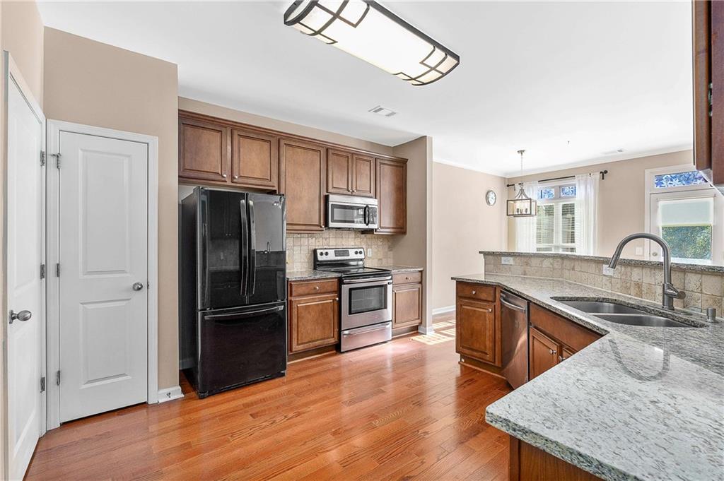 3546 Flycatcher Way Duluth, GA 30097 - Photo 7 of 30 a kitchen with granite countertop a refrigerator stove and sink
