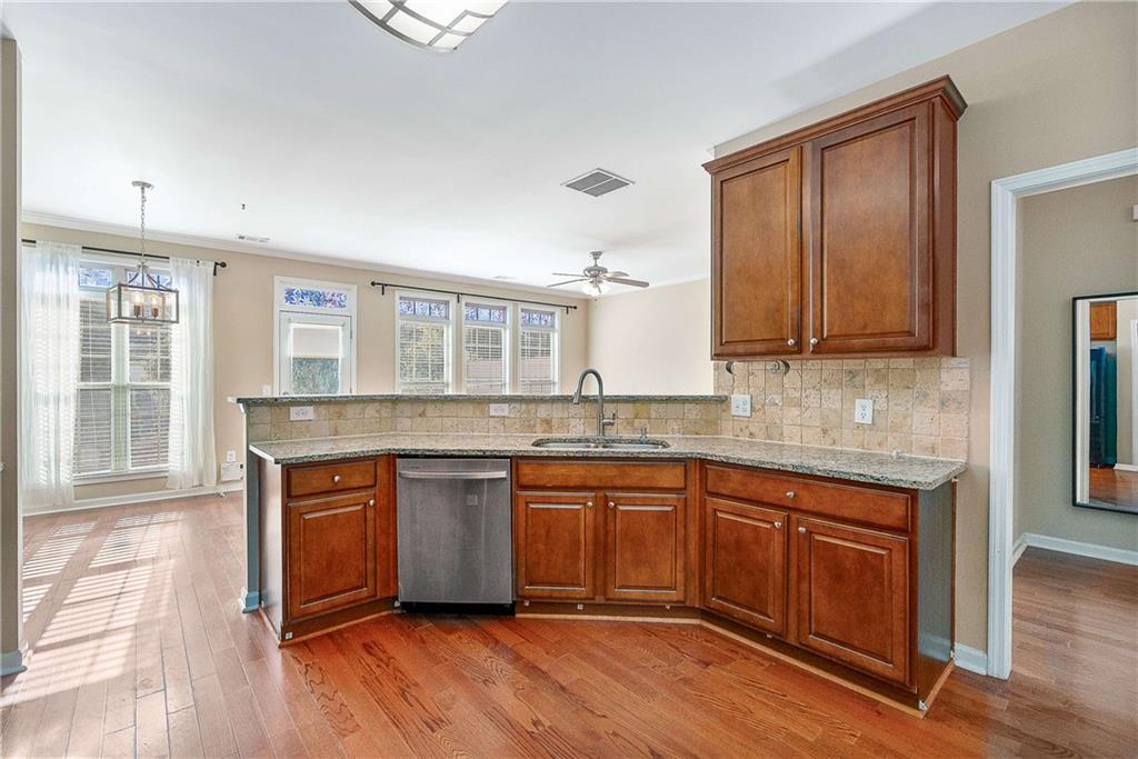 3546 Flycatcher Way Duluth, GA 30097 - Photo 8 of 30 a kitchen with stainless steel appliances granite countertop a stove a sink dishwasher and a microwave oven with wooden floor