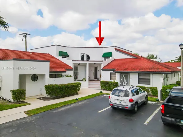 a front view of a house with a garden and parking
