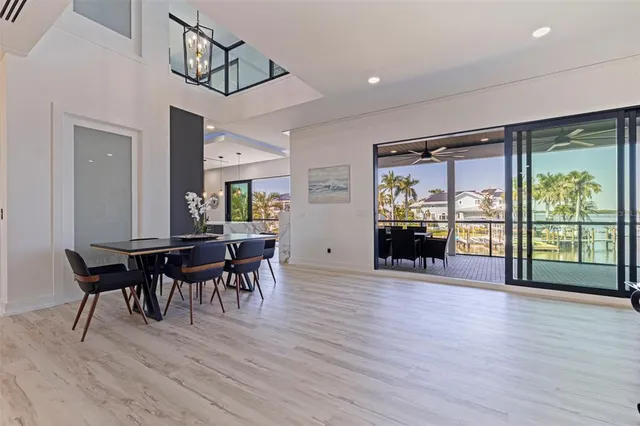 a kitchen with stainless steel appliances granite countertop a kitchen island a stove a refrigerator a sink and a dining table with wooden floor