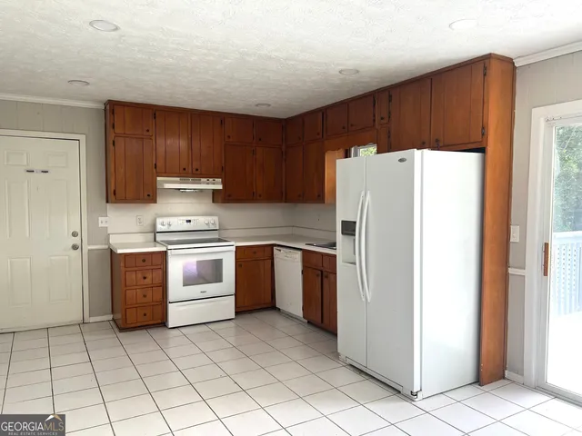 a kitchen with a refrigerator sink and cabinets