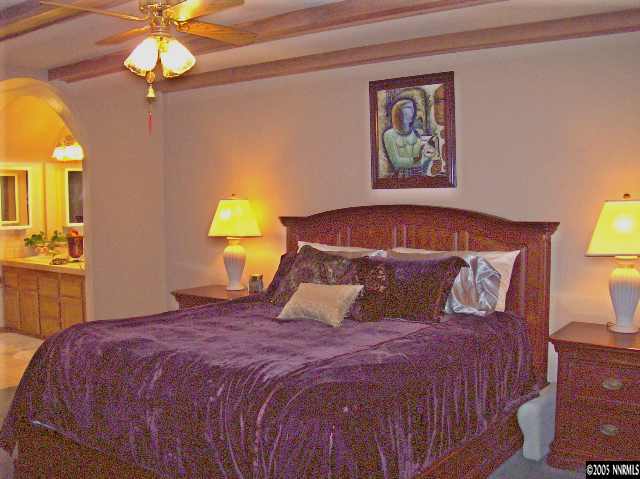 14565 Rim Rock Drive Reno, NV 89521 - Photo 6 of 8 a bedroom with a bed and a chandelier