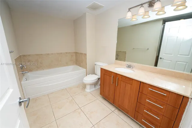 a bathroom with a bathtub sink mirror and toilet