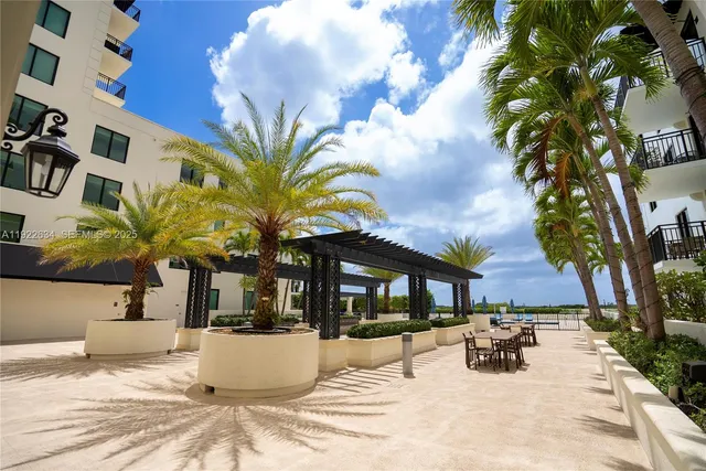 a view of a white house with a yard and sitting area