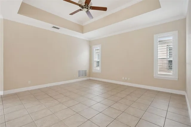 an empty room with wooden floor and a ceiling fan