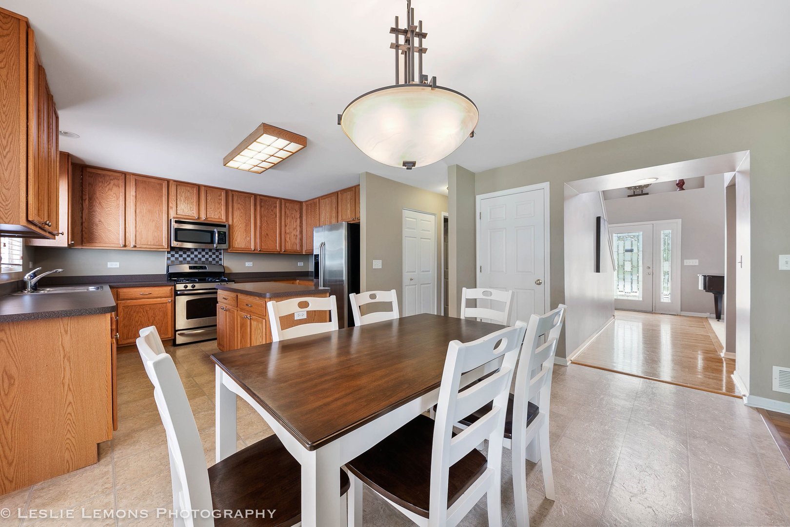128 Reston Court Sycamore, IL 60178 - Photo 4 of 30 a kitchen with stainless steel appliances granite countertop a dining table chairs refrigerator and microwave