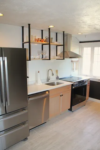a kitchen with stainless steel appliances a sink and a refrigerator