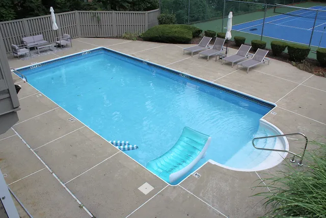a view of yard with swimming pool and seating space