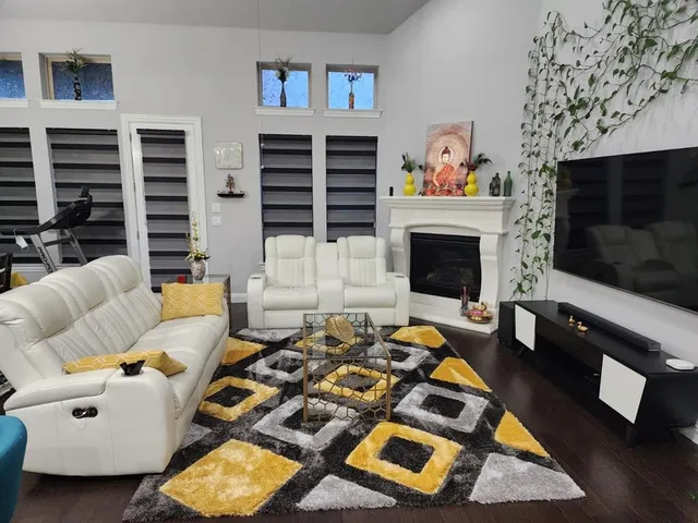 a living room with furniture a flat screen tv and a fireplace