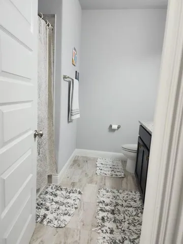 a bathroom with a granite countertop sink a toilet and a mirror
