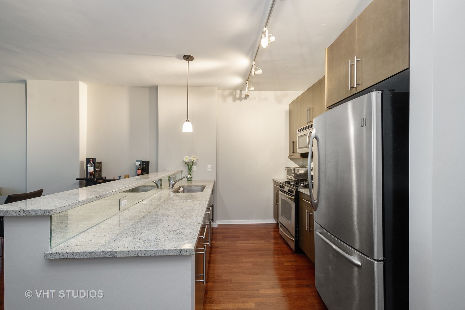 123 South Green Street, Unit 909B Chicago, IL 60607 - Photo 4 of 11 a kitchen with granite countertop a refrigerator and a sink