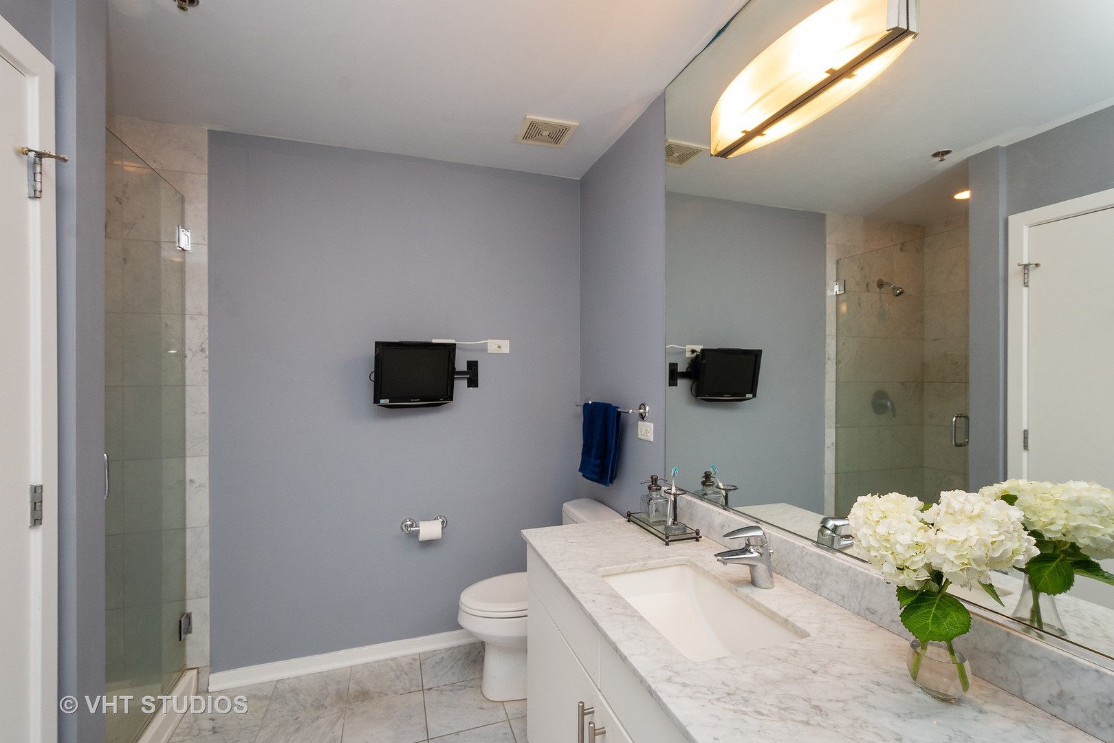 123 South Green Street, Unit 909B Chicago, IL 60607 - Photo 8 of 11 a bathroom with a granite countertop sink a toilet and a mirror