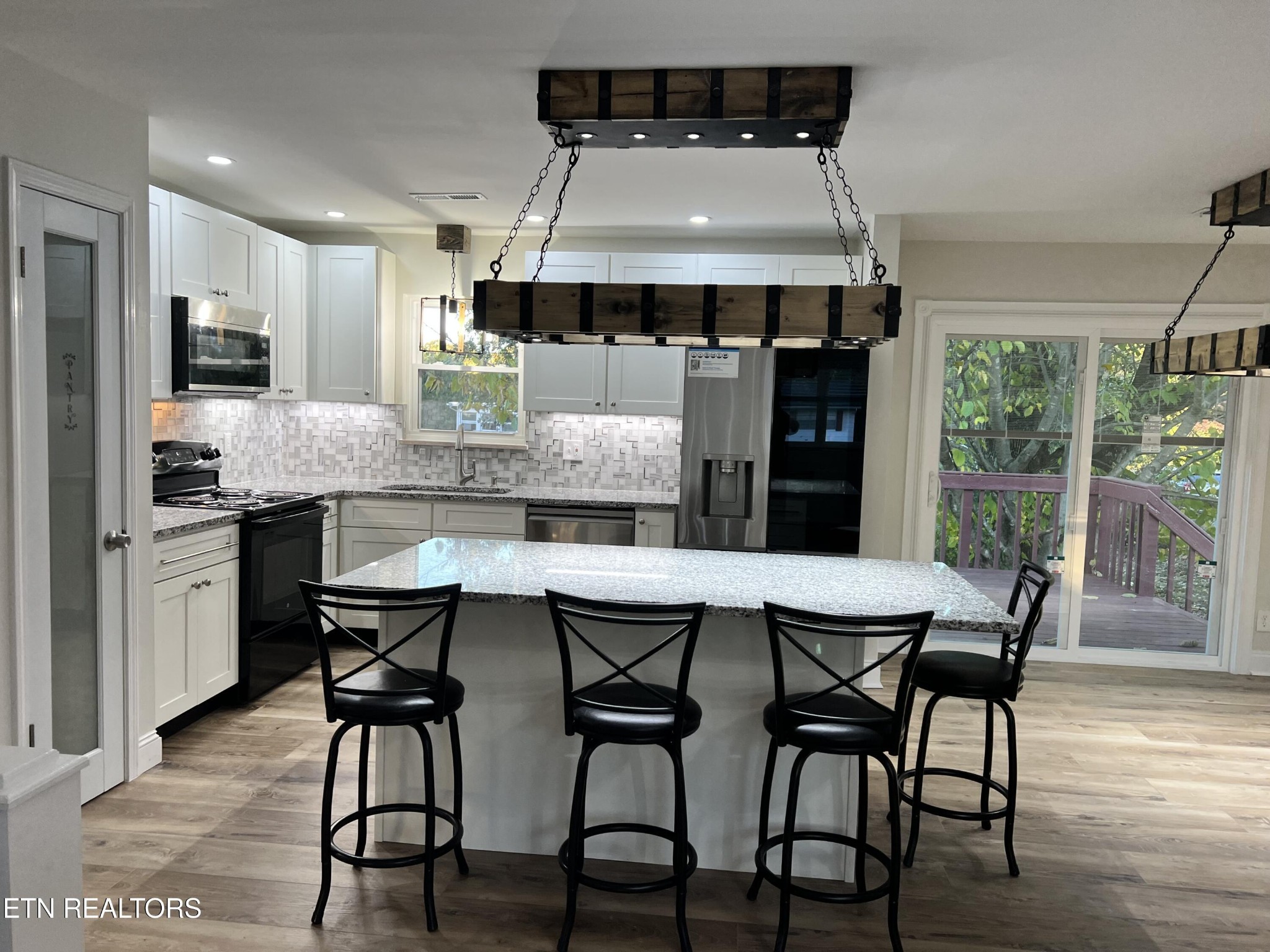 244 Peterson Road Knoxville, TN 37934 - Photo 10 of 46 a kitchen with stainless steel appliances a dining table chairs and wooden floor