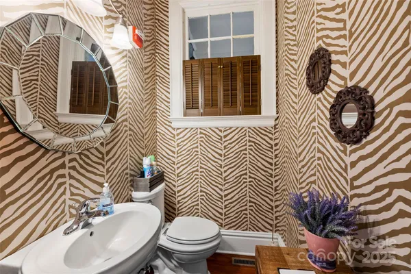 a bathroom with a sink a toilet and mirror