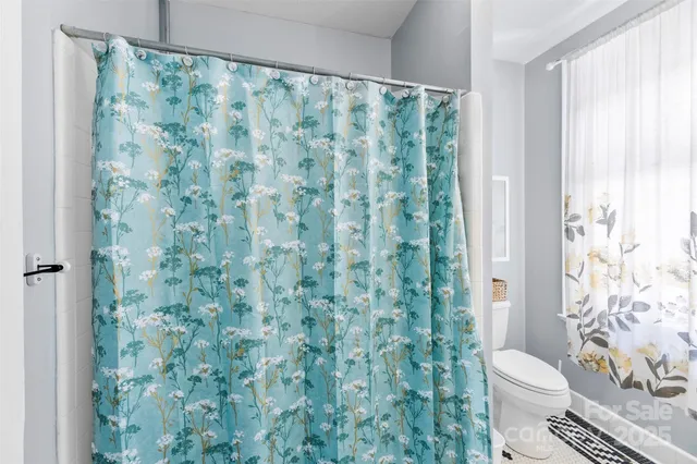 a white toilet sitting next to a shower curtain